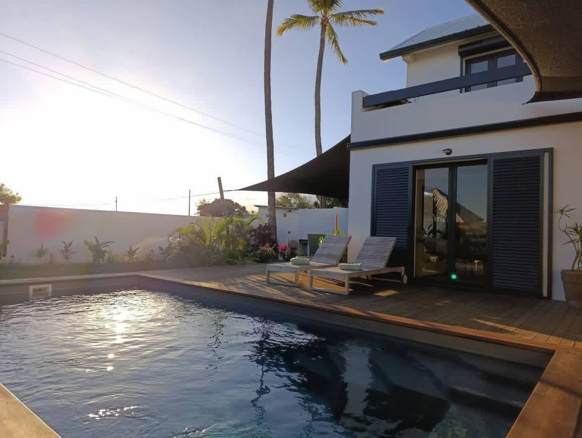 Piscine au coucher de soleil avec palmiers