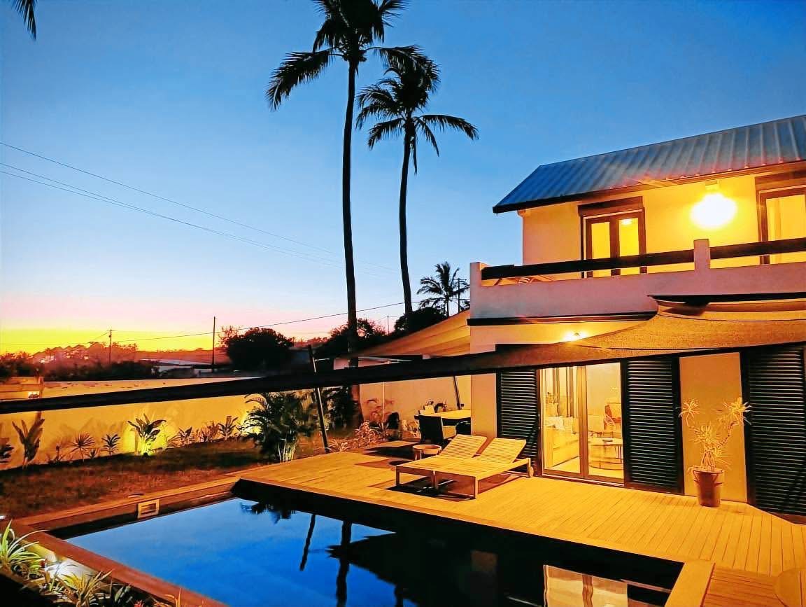 Villa au coucher de soleil avec palmiers